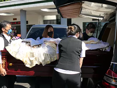 工作人員將靈柩台上靈車